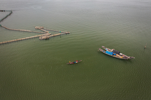 Drone view of fishing boats by the fish fence trap on Con Te lagoon in morning - Thua Thien Hue province, central Vietnam