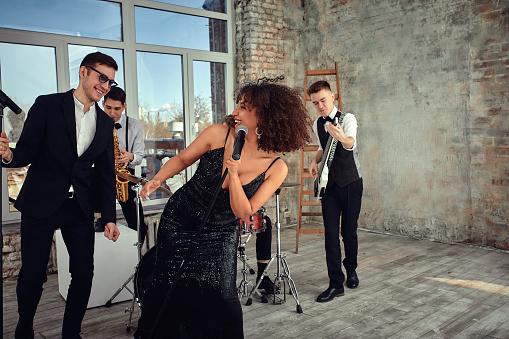 Young international musicians, a band performing on the loft stage. The concept of music, hobby, festival. Inspiration creativity.