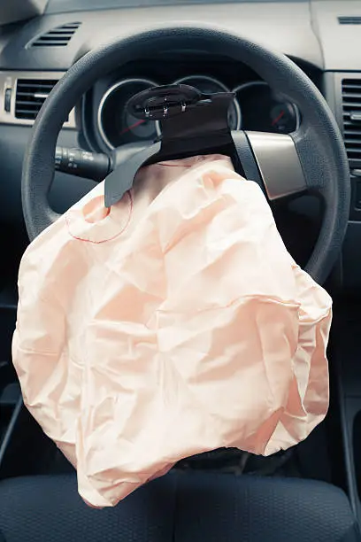 Exploded airbag on steering wheel of crashed car
