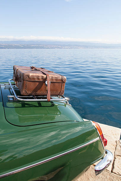 Back of a vintage sports car with an old leather case