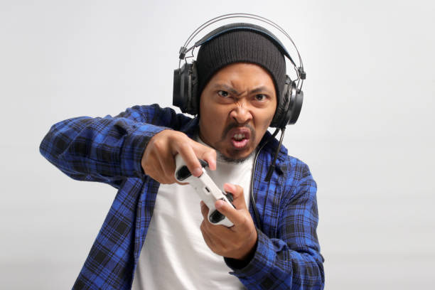 istock Angry Asian gamer playing a video game using a gamepad 1861954251