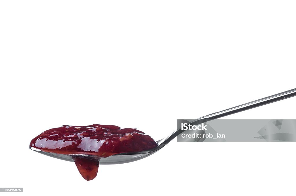 Raspberry jam Raspberry jam dripping from a spoon isolated on white background Preserves Stock Photo