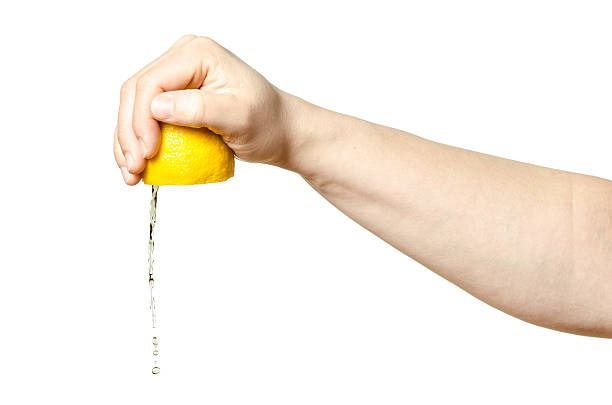 Hand squeezing lemon stock photo