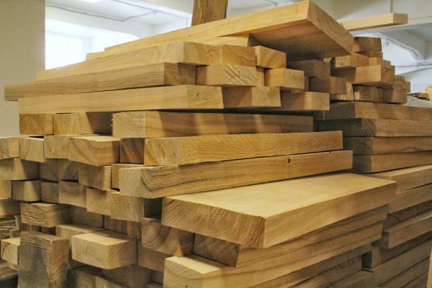Close-up of wooden planks at lumber warehouse. Storage shelves with panel in lumberyard. Background of boards on shop. Processed timber blocks products in market. Raw wood drying in carpenter workshop primer plano de tablones de madera en almacén de madera. estantes de almacenamiento con panel en aserradero. antecedentes de los tableros en la tienda. productos de bloques de madera procesados en el mercado. secado de madera cruda en taller de carpinter�