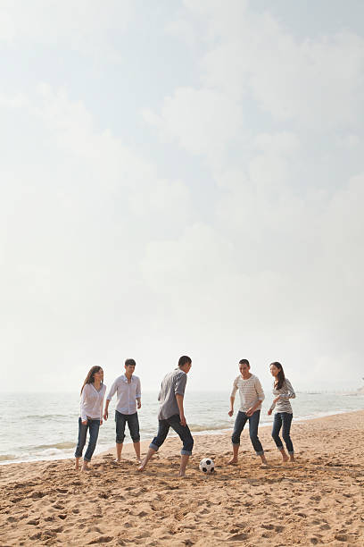 istock Young Friends Playing Soccer on the Beach 186196962