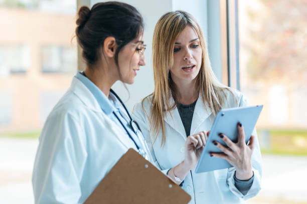 istock Two attractive female doctors talking while consulting results in digital tablet in the hospital. 1861978506