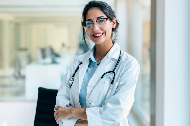 Smiling female doctor looking at camera in the medical consultation. Shot of smiling female doctor looking at camera in the medical consultation. female doctor stock pictures, royalty-free photos & images