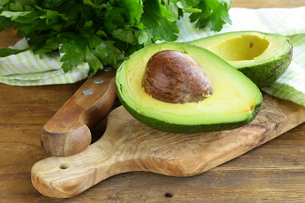istock ripe avocado cut in half on a wooden table 186205229