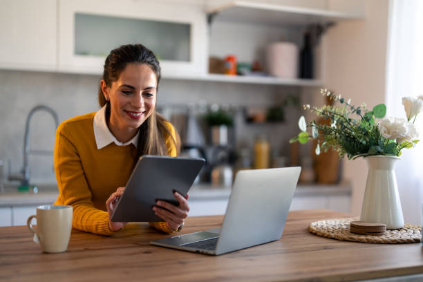 istock Female digital nomad working from home using digital tablet and laptop computer 1862065591
