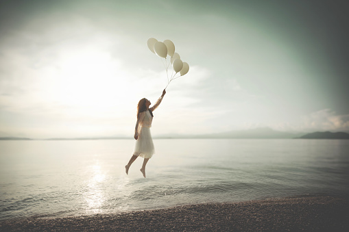 surreal woman flies carried by balloons, abstract concept