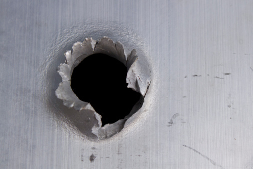 .50 Caliber bullet hole through 3/4 inch aluminum plate.