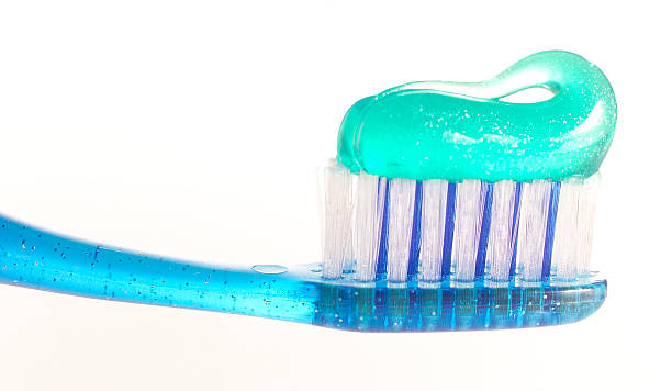 toothbrush blue toothbrush green paste toothpaste stock pictures, royalty-free photos & images