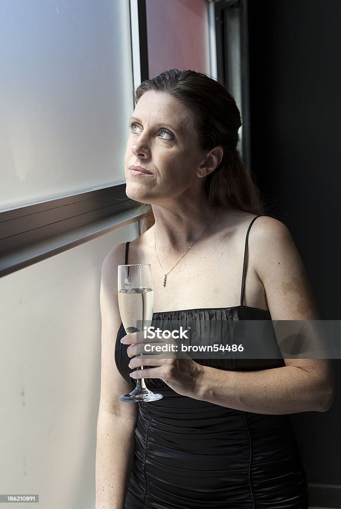 Middle Aged Woman in Black Dress with Champagne Portrait of a beautiful woman in a black dress with Champagne. Adult Stock Photo