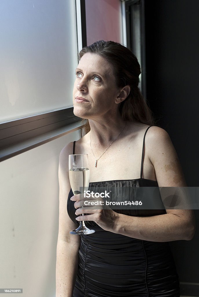 Средний возрасте женщина в черном платье с шампанским - Стоковые фото Алкоголь - напиток роялти-фри