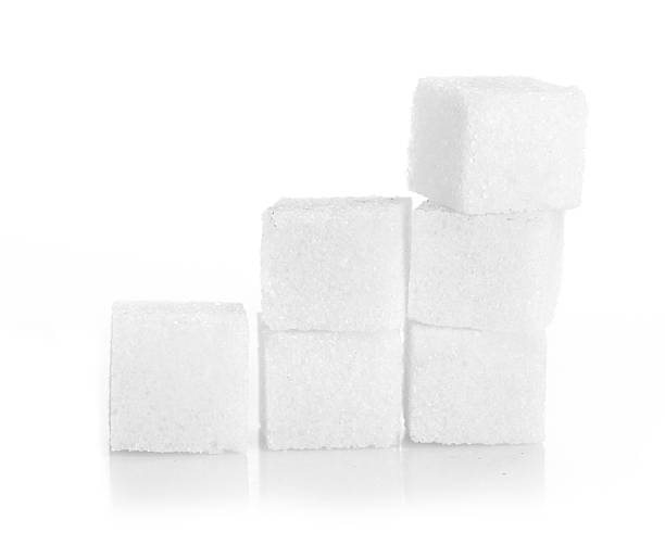 Studio photography of a lump sugar Studio photography of a lump sugar pile in light back sugar cube stock pictures, royalty-free photos & images