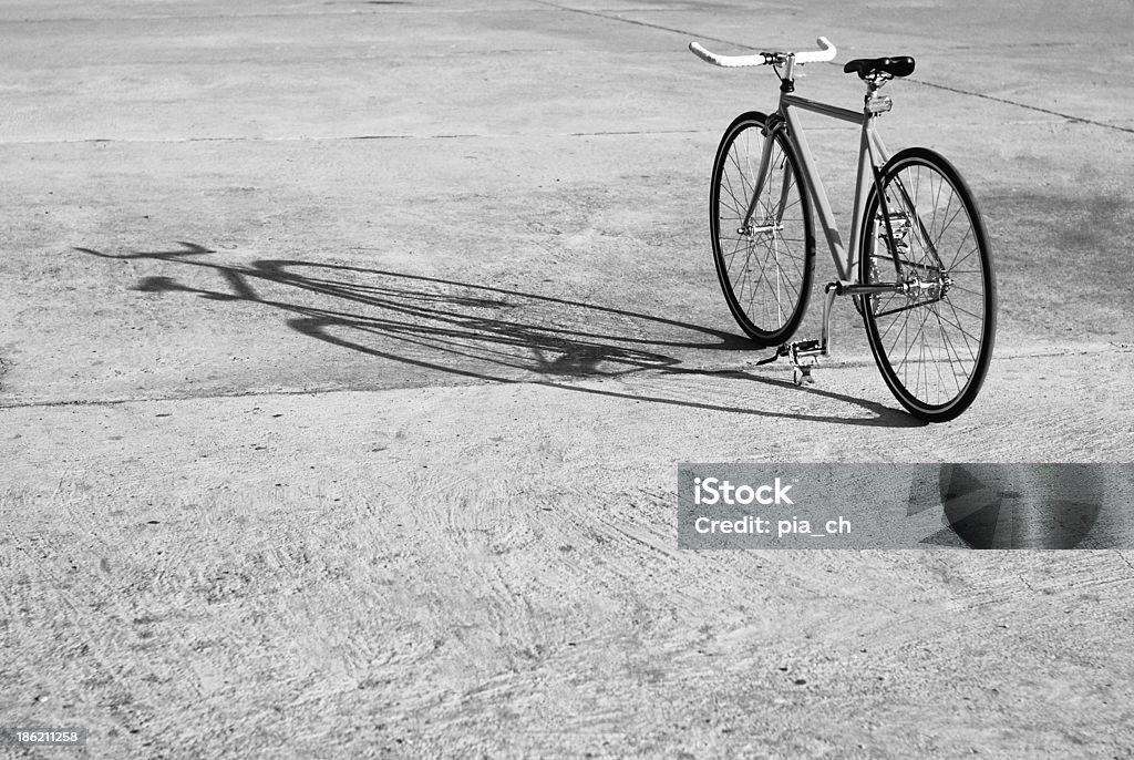Bicycle and its shadow Single-speed or fixed gear bicycle standing in the parking lot Bicycle Stock Photo