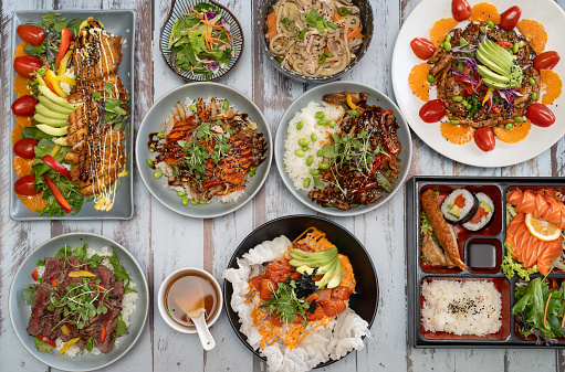 top down view of mixed asian dishes on rustic wooden table