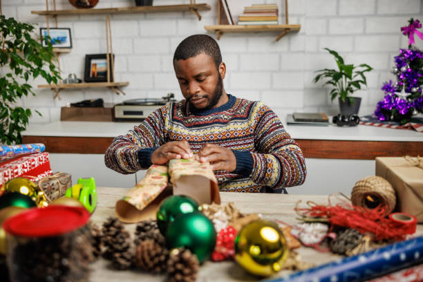 istock Young man wrapping Christmas gifts at home 1862134776