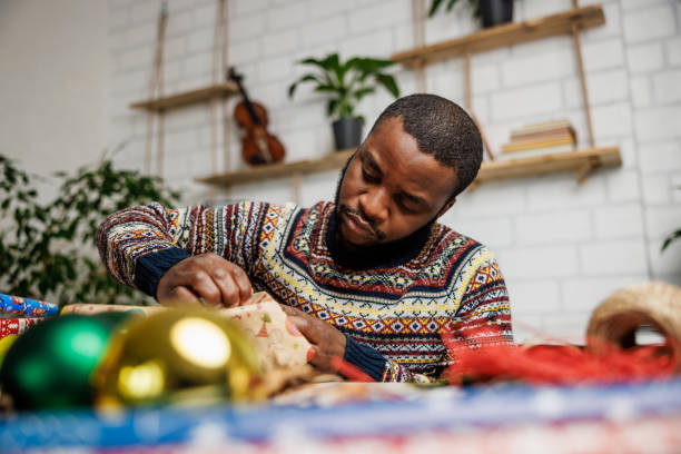 istock Young man decorates Christmas gifts 1862134826