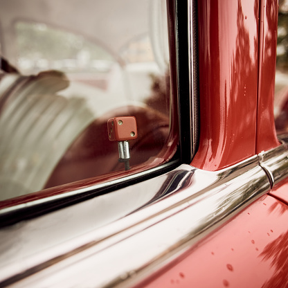 Close up of classic car door lock with red dice.