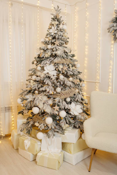 istock Christmas tree with in artificial snow, with festive decorations, white xmas glittering baubles, balls, shiny flower ornaments. Garland with gold lights Illuminate on backdrop. New year 2025 holidays. 1862165900