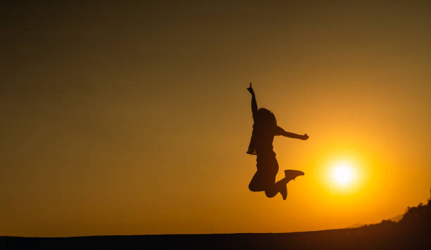 silhouette di donna che salta e successo per l'obiettivo sul prato del campo con bellissimo sfondo di luce del sole al tramonto per banner web e pubblicità. - arms raised green jumping hand raised foto e immagini stock