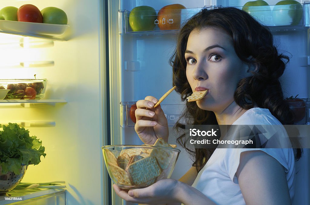 fridge with food a hungry girl opens the fridge Snack Stock Photo