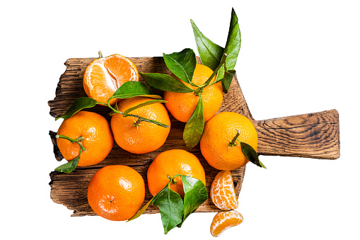 Mandarin oranges or tangerines fruits with leaves on wooden board.  Isolated on white background