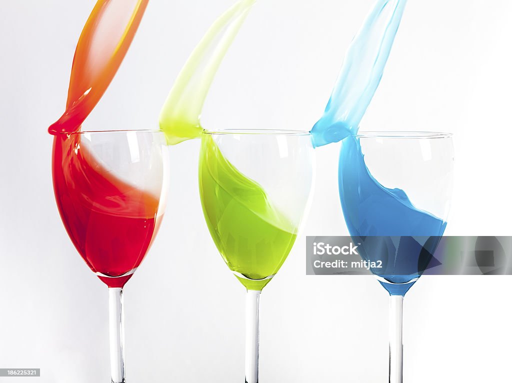 RGB splash Conceptual image of Red Green and Blue liquid splashing out of a glass isolated on a white background. Art Stock Photo