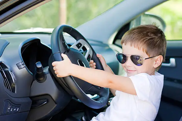 Photo of Cute young driver pretending to drive a car