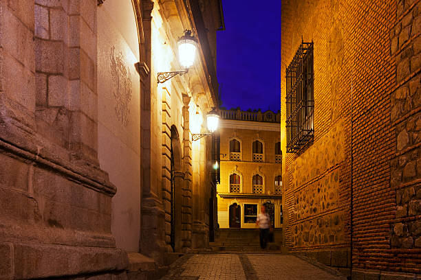 Toledo, Spain - March 17, 2023:  of the Real Alcazar of Toledo, Spain (today a military museum) illuminated at night above the houses and walls. UNESCO World Heritage Site