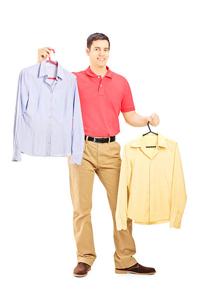 istock Smiling male holding two hangers with shirts 186228179
