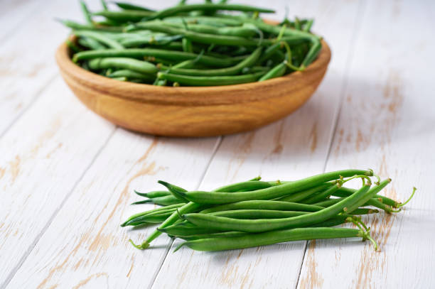 istock fresh green beans in a bowl on a wooden table, copy space for text. 1862284658
