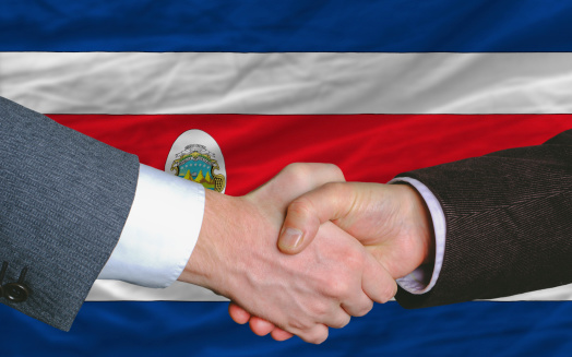 businessmen handshakeafter good deal in front of costarica flag