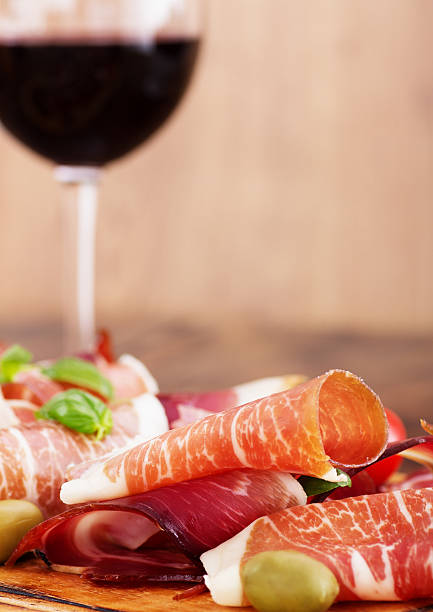 istock sliced prosciutto with red wine and olives 186229058