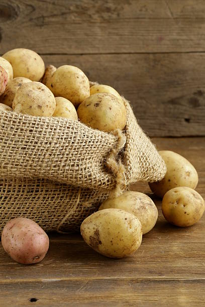 istock fresh organic potatoes on a wooden background, rustic style 186230866