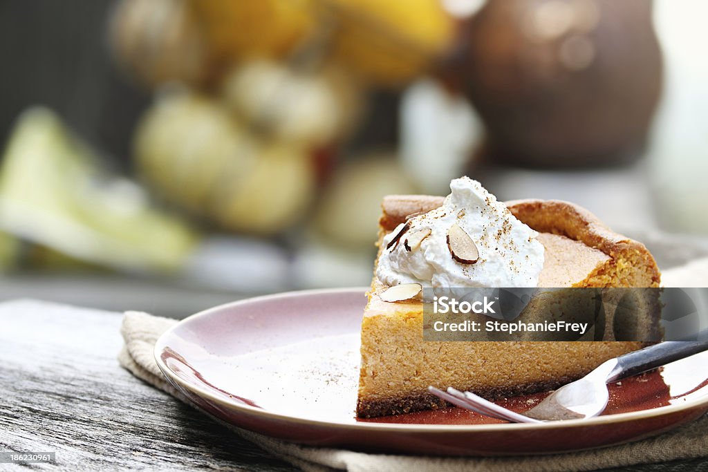 Pumpkin Cheesecake Pie A slice of Pumpkin Cheesecake Pie with homemade whipped cream, almonds and pumpkin spice. Extreme shallow depth of field. Cheesecake Stock Photo