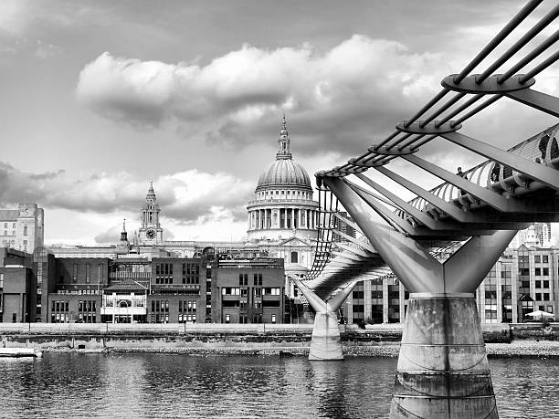 Locals and tourists on the Millenium Bridge over the River Thames in central London, with St Paul's cathedral at the end of the bridge.