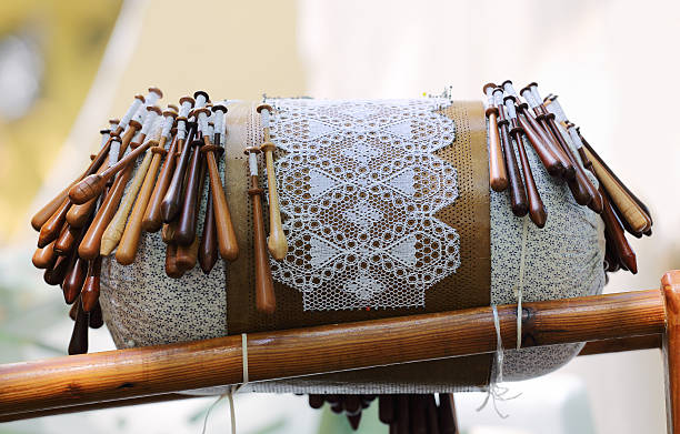 Bobbin Lace Equipment Traditional equipment for lace making - wooden bobbins on lace pillow with pricked paper pattern. lacemaking photos stock pictures, royalty-free photos & images