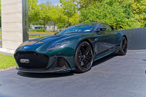 Parked dark green Aston Martin sports car type Superleggera outside of garage at Swiss City of Opfikon on a sunny summer day. Photo taken July 23rd, 2023, Opfikon, Canton Zürich, Switzerland.