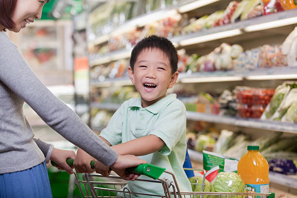 istock Young boy smiling, sitting in a shopping cart 186233270