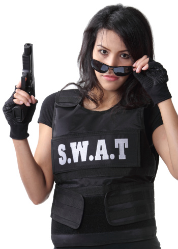 asian woman wearing swat bulletproof vest and holding a gun on her hand