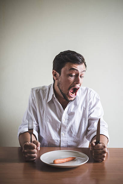 istock young stylish man with white shirt eating carrot 186236134