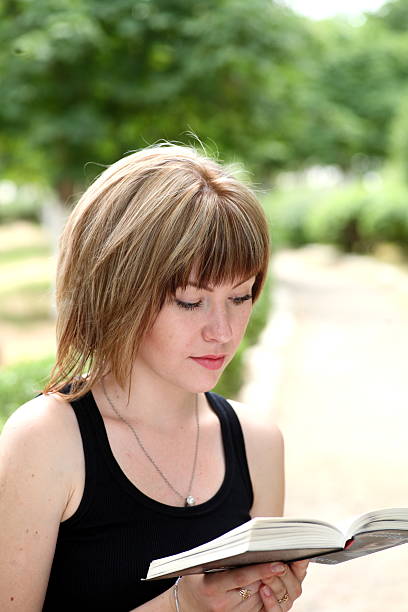 istock Attractive girl student reading book 186238409