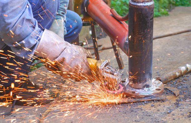 mão de soldador usando máquina de moagem elétrica para polir flange de metal em tubo de aço para melhorar o trabalho do sistema de oleoduto - flange grinder grinding pipe - fotografias e filmes do acervo