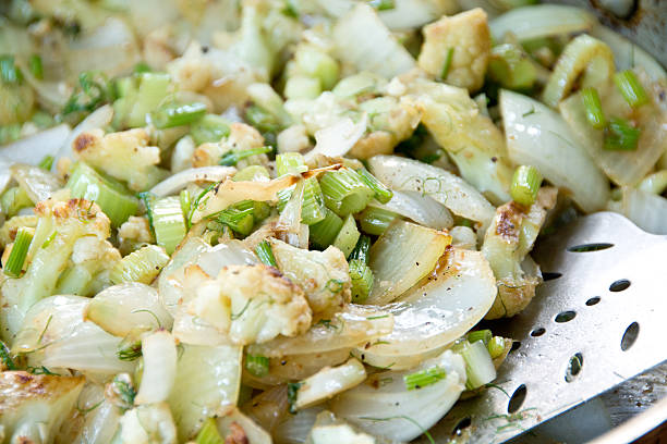 This vegetable dish contains stir-fried fennel, sweet onions, and cauliflower, and is spiced with black pepper and salt.