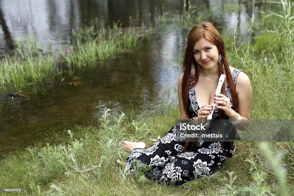 portrait of beautiful young woman in park Close-up portrait of beautiful young woman playing flute, outdoors 20-24 Years Stock Photo