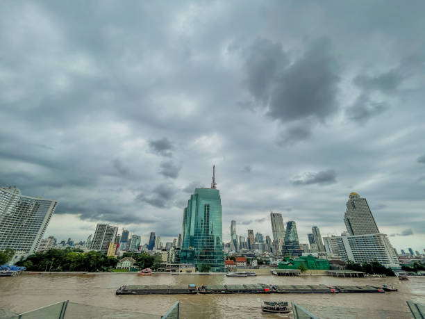 Skyscrapers along Chao Praya river, boat traffic on the rive