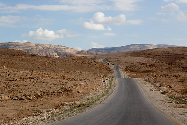 istock Road going into the dry desert distance 186249415