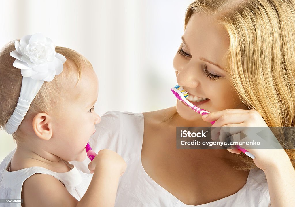 Madre e hija bebé niña cepillar los dientes juntos - Foto de stock de Bebé libre de derechos